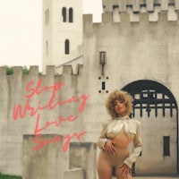 a woman is standing in front of a castle with the words stop writing love songs